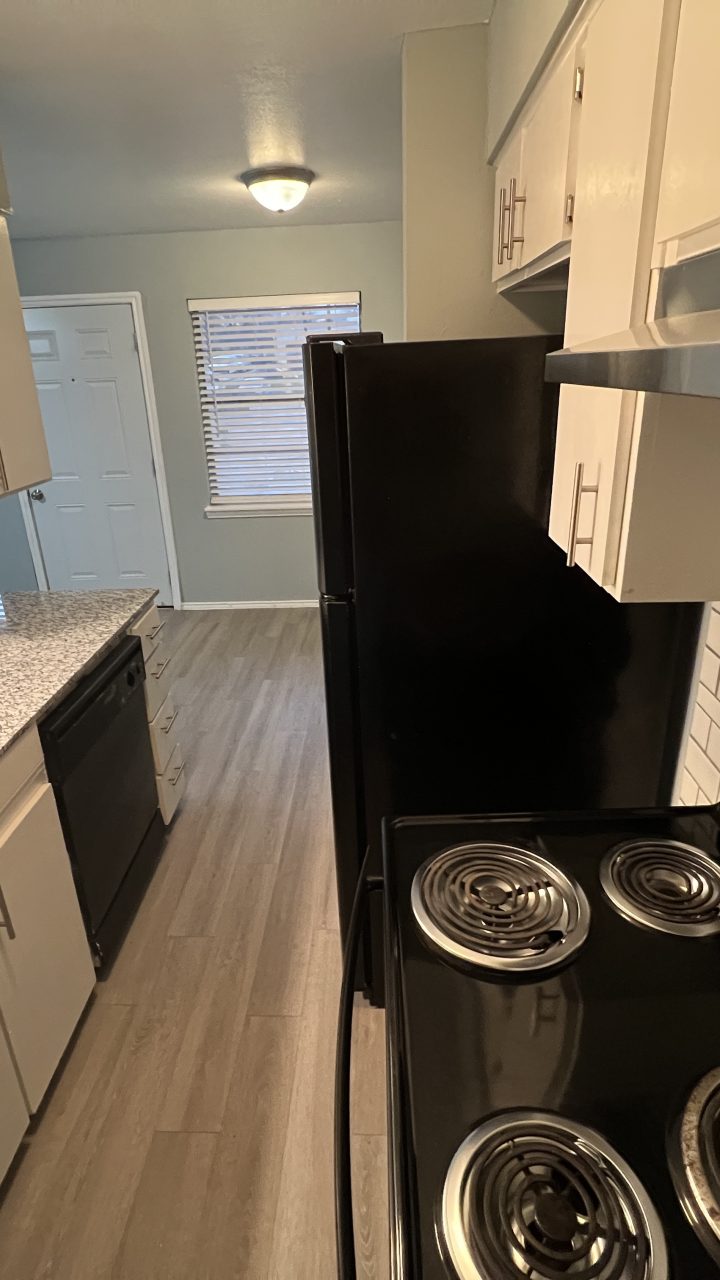 a kitchen with a stove, oven, and microwave at The Hampton Gardens